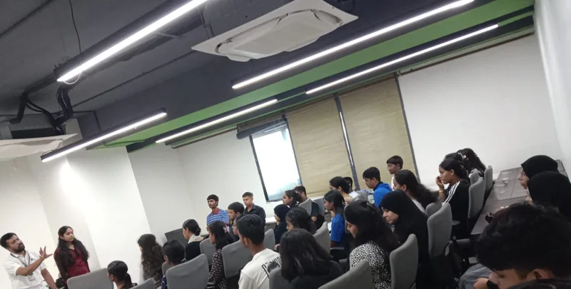 Two MindMints facilitators addressing around thirty young people seated in a training room